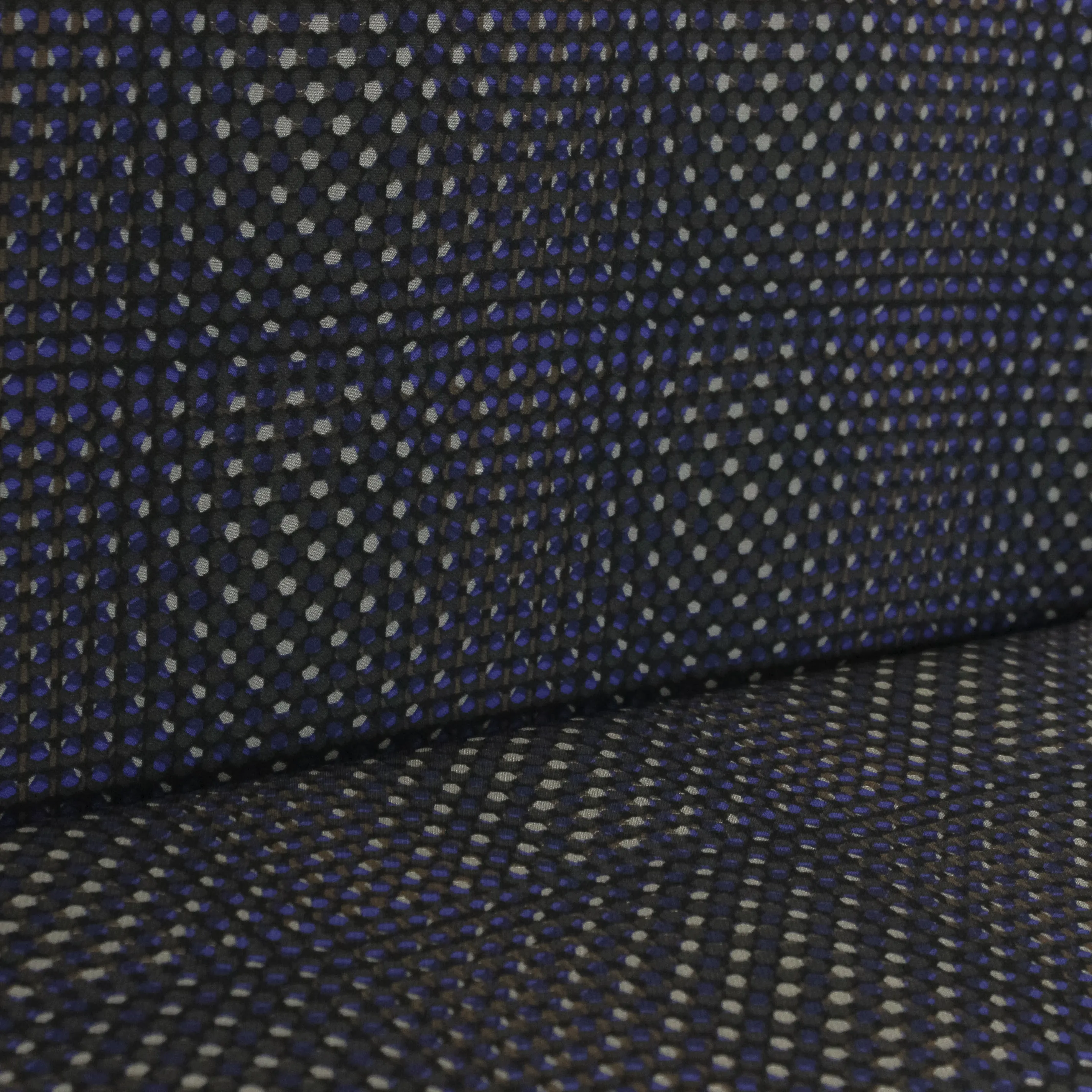Polyester tricot met blauw en bruin patroon van kleine bolletjes